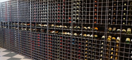A contemporary floor-to-ceiling retail wine rack elegantly showcasing an extensive collection of wine bottles