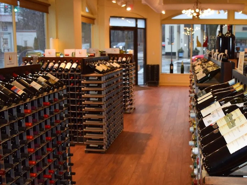 Wide interior view of Vintology's current storefront layout with wine racks and large street-facing windows